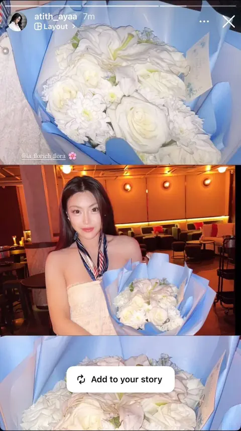 ลูกค้าถือช่อกุหลาบขาวห่อกระดาษฟ้า
